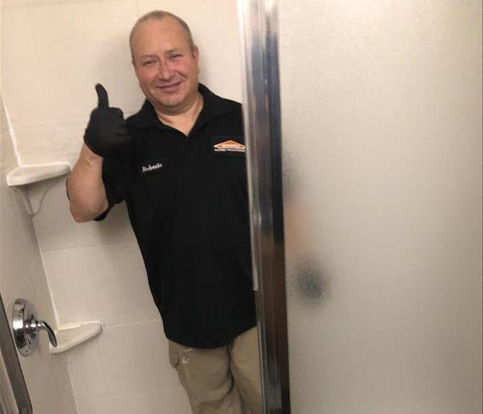 Employee smiling in a clean shower.